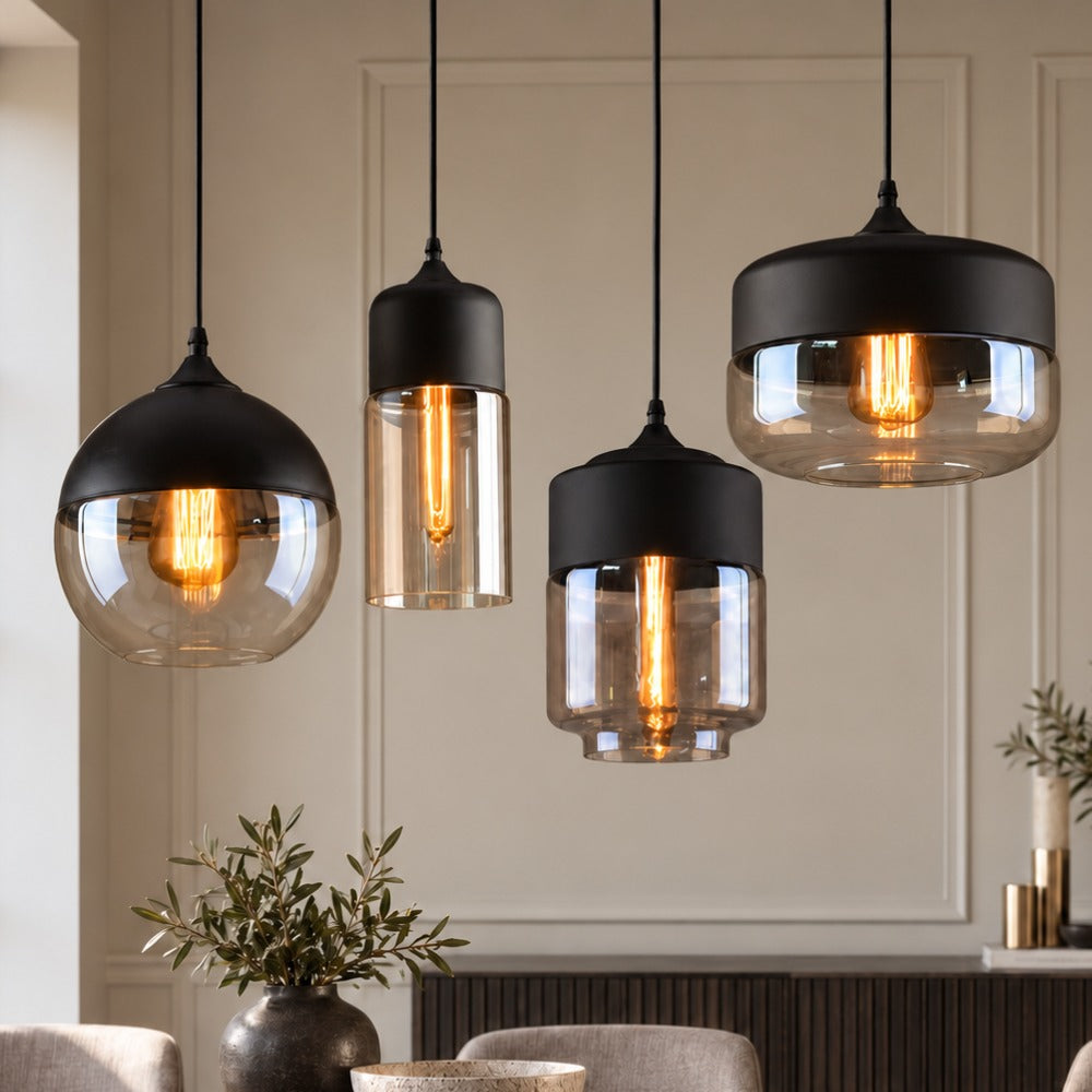 Four Blended Combination Metal Glass Pendant Lights in mixed shapes with amber and clear glass against a panelled wall