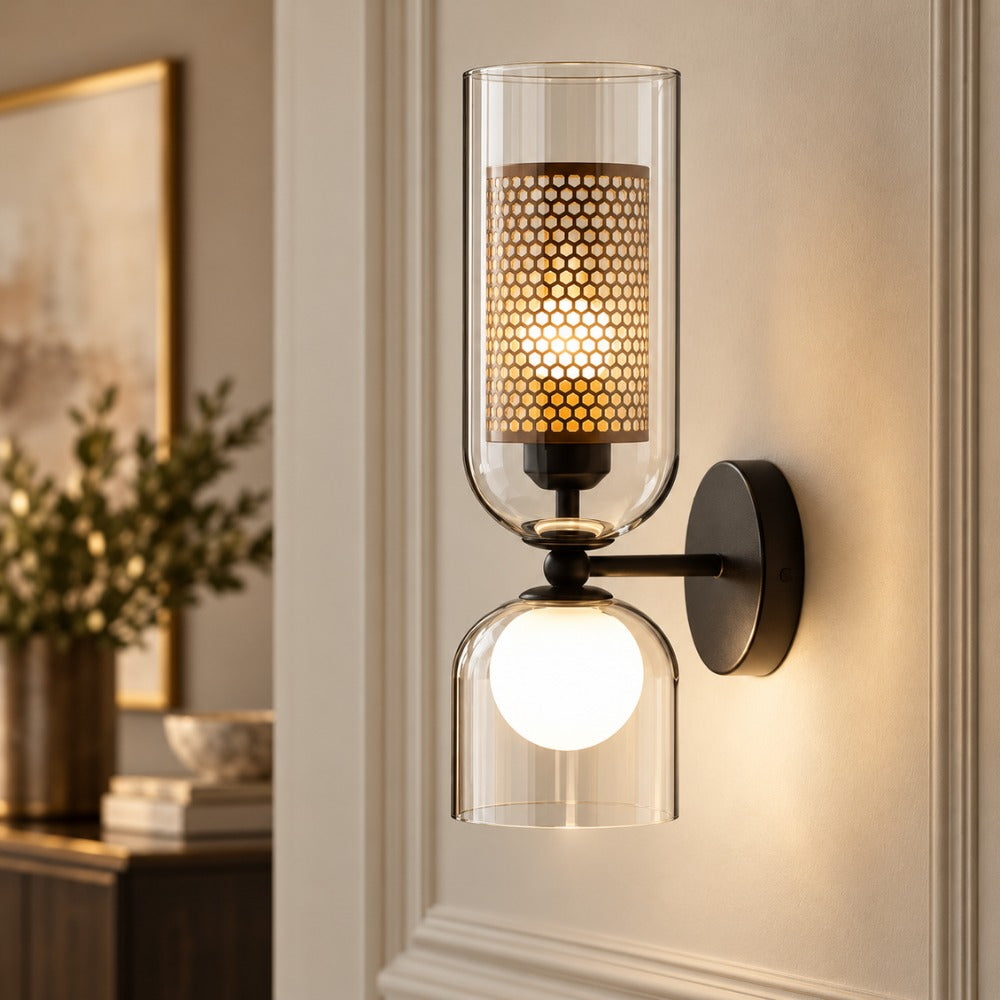 Cylindrical Twin Glass Wall Lamp with clear glass cylinder, gold mesh shade and frosted globe on a panelled wall