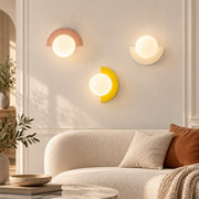 Minimalist Arc Colorful Nordic Wall Lamp Sconce Light Fixtures pink, yellow and white beside a living room sofa