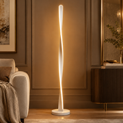 Modern Spiral Long Line Dimmable Floor Lamp white spiral LED floor lamp glowing beside an armchair in a warm room