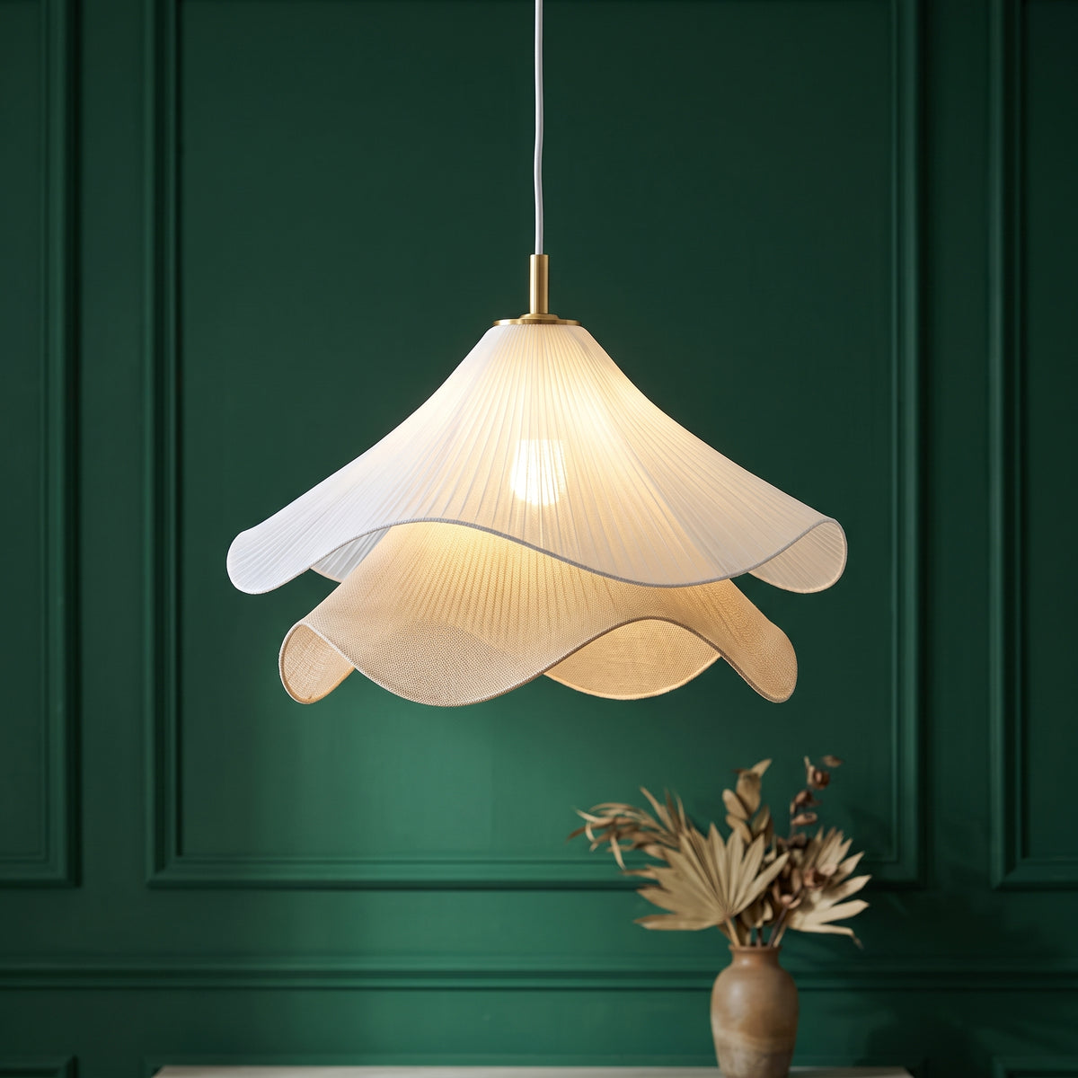 Nordic French Art Pleated Fabric Petal Chandeliers white pleated fabric petal chandelier glowing against a dark green panelled wall