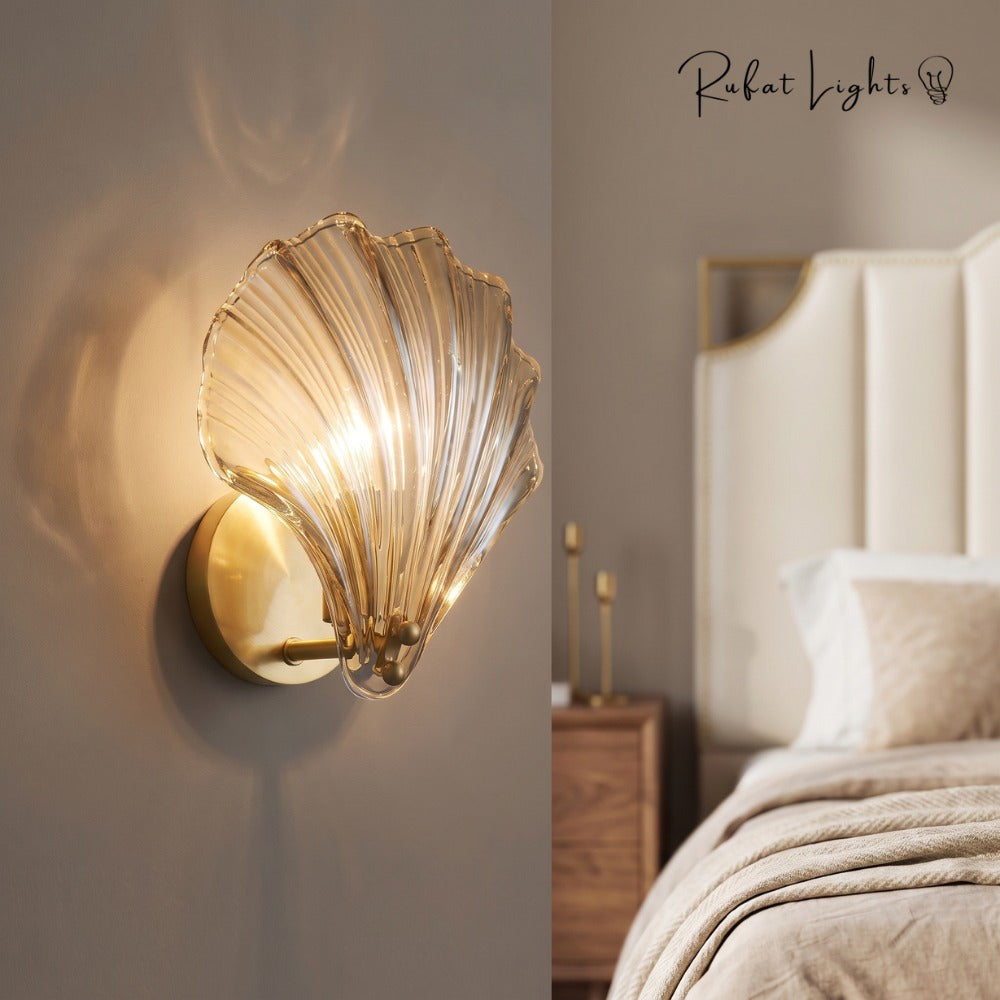 Oceanic Glass Shell Wall Light wall light in clear glass beside a bed