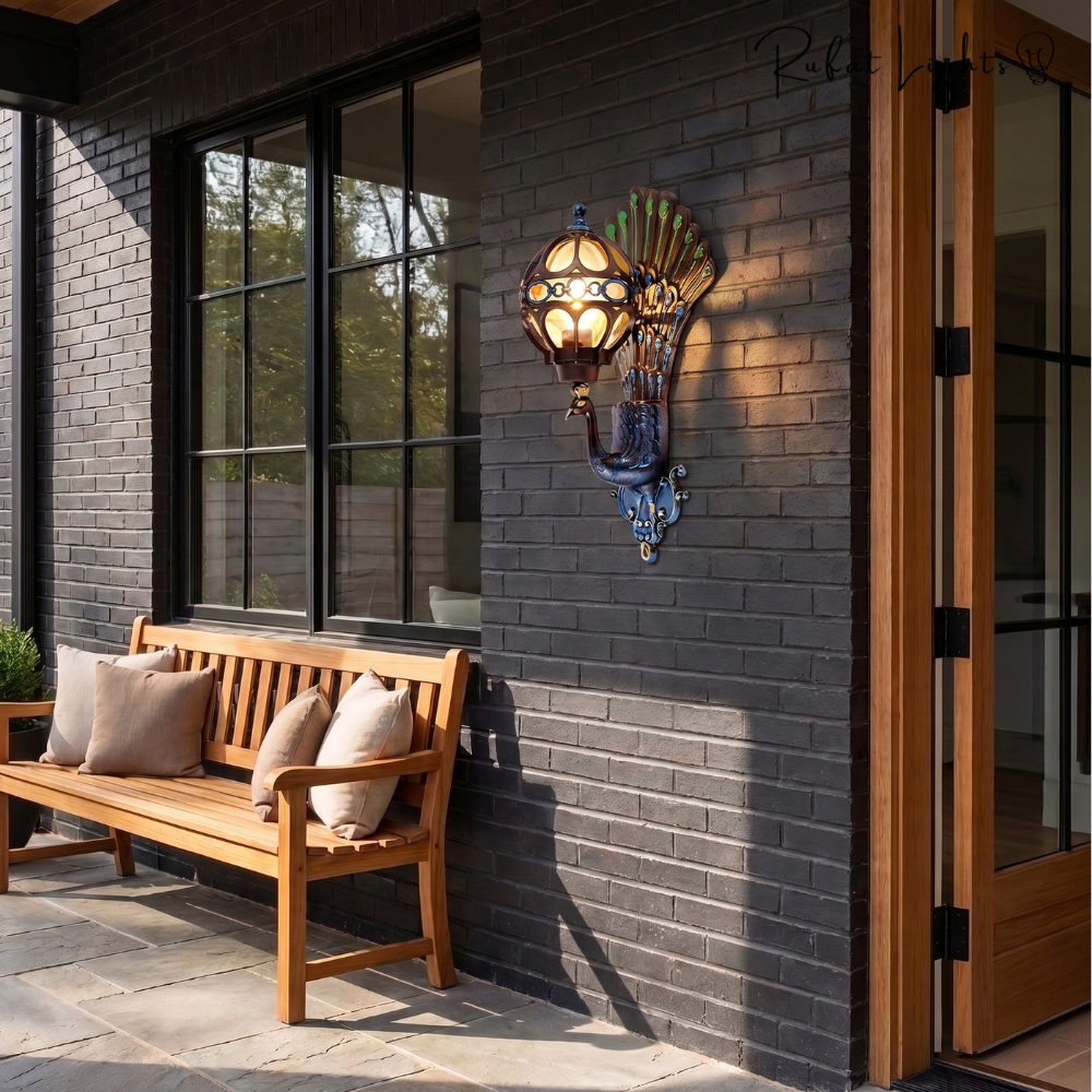 Retro Peacock Indoor Outdoor Wall Light in Colorful on a dark brick porch wall above a wooden bench