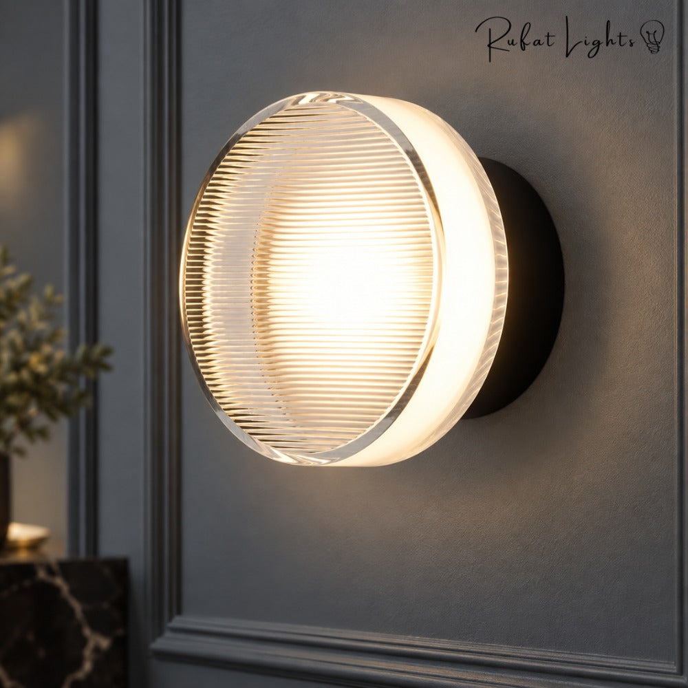 Round Textured Glass Wall Lamp in black close-up on a dark panelled wall