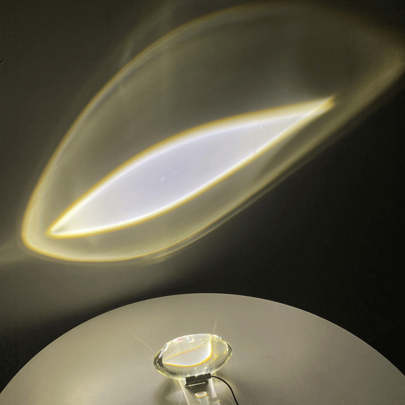 Mystical Radiance Crystal Sky Lamp in White projecting a leaf-shaped light glow onto a dark wall